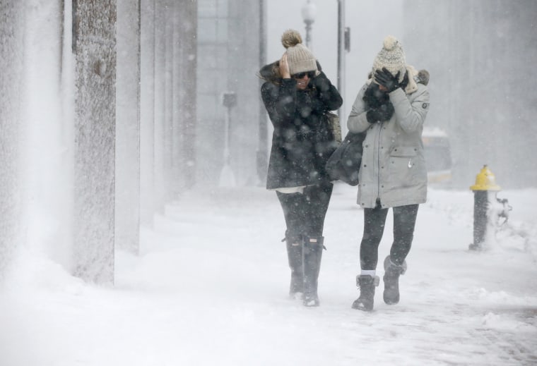 Image: Two women struggle to walk in the blowing snow during a winter storm