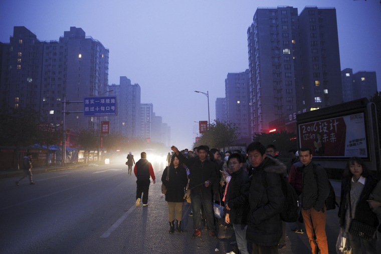 Image: People wait for a bus to Beijing 