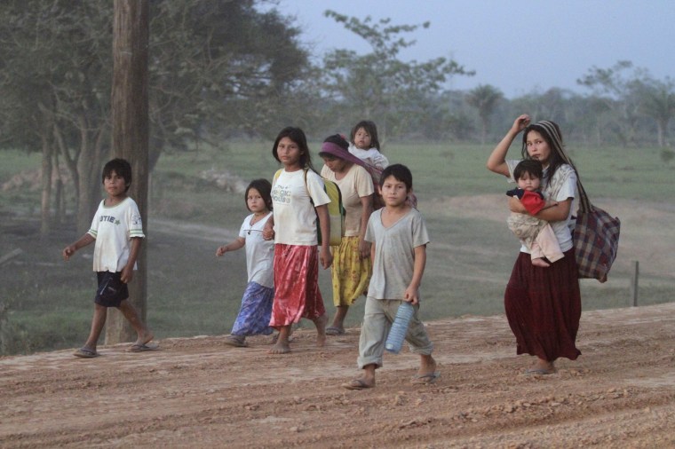 Image: Tsimane indigenous people walk down a road heading to Yucomo, Bolivia