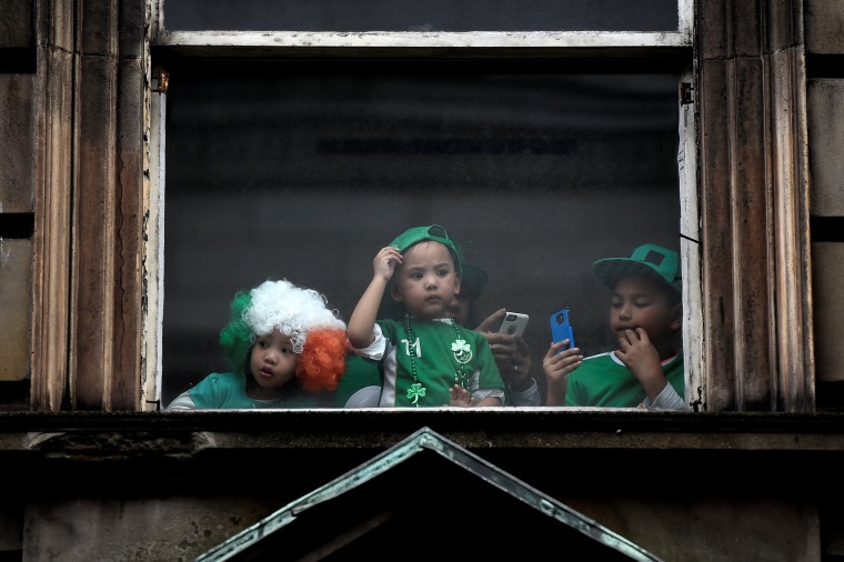 Image: Children watch the St. Patrick's day parade from a window in Dublin