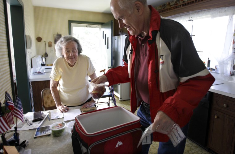 Image: Marty Robertson unpacks food from the Chagrin Falls Meals on Wheels program for recipient Bernadette Winko, 90, in her Bentleyville, Ohio home on Wednesday, March 14, 2012.