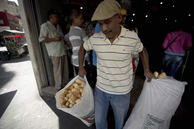 An employee of the Minka state-run bakery carries bags of bread to be distributed to state-run grocery stores in Caracas, Venezuela.