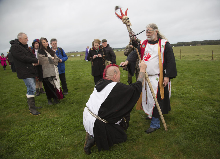 Image: King Arthur Uther Pendragon knights a fellow druid at Stonehenge