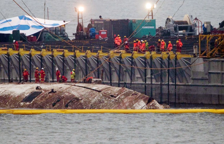 Image: The sunken ferry Sewol is raised during its salvage operations at the sea off Jindo