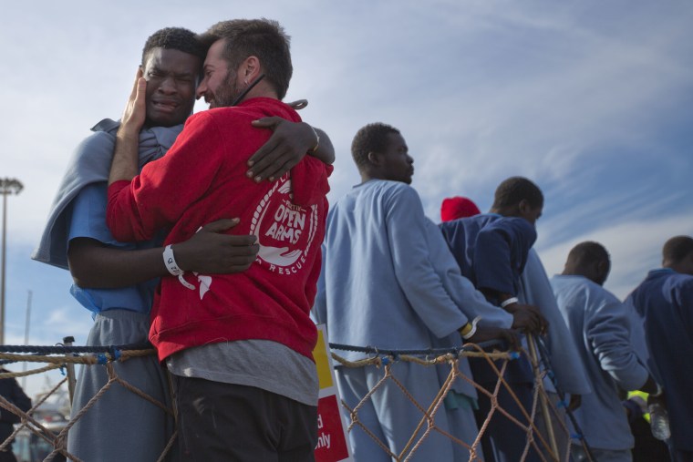 Kybumba Fran, 25, from Cameroon, cries with the head of the mission of Proactive Open Arms NGO Riccardo Gatti, from Italy, as he leaves the Golfo Azzurro rescue vessel after arriving at the port of Pozzallo, south of Sicily, Italy, with more than 220 migrants aboard the ship rescued at the Mediterranean sea, on Sunday, Feb. 5, 2017.
