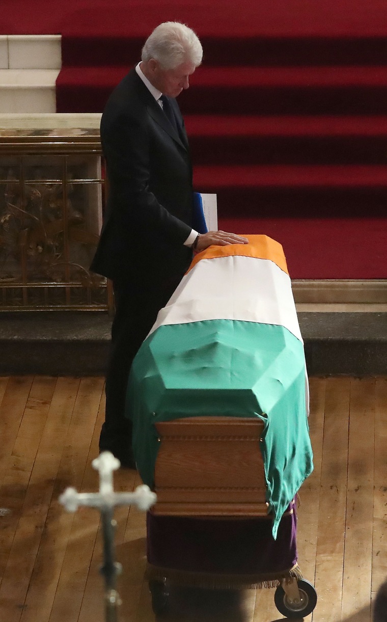 Image: Former President Bill Clinton touches Martin McGuinness's coffin