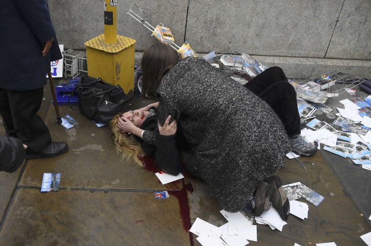 Image: A woman lies injured after a shotting incident on Westminster Bridge in London