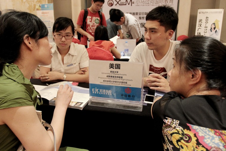 Image: Education consultants talk with visitors about studying in the United States during an education expo in Wuhan, central Chinas Hubei province, July 6, 2013.