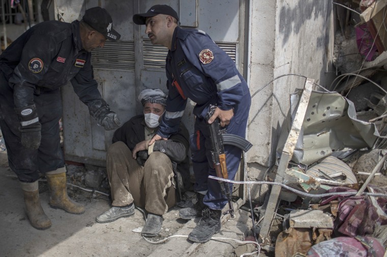 Image: A man is helped after identifying the body of a relative who died in a house that was destroyed during fights between Iraqi security forces and the Islamic State on the western side of Mosul, March 24.