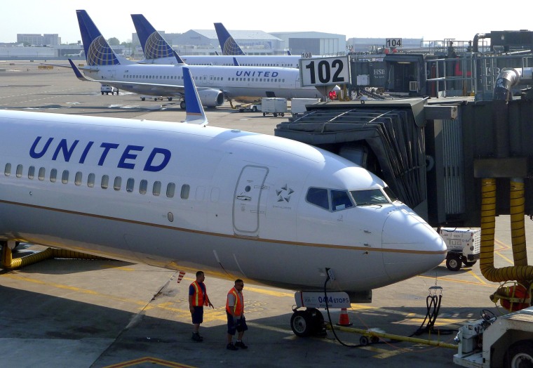 Image: A United Airlines airplane sits at a gate.