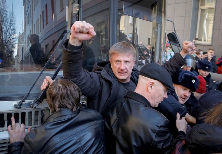 Image: An opposition supporter gestures as he blocks a police van transporting detained anti-corruption campaigner and opposition figure Alexei Navalny.