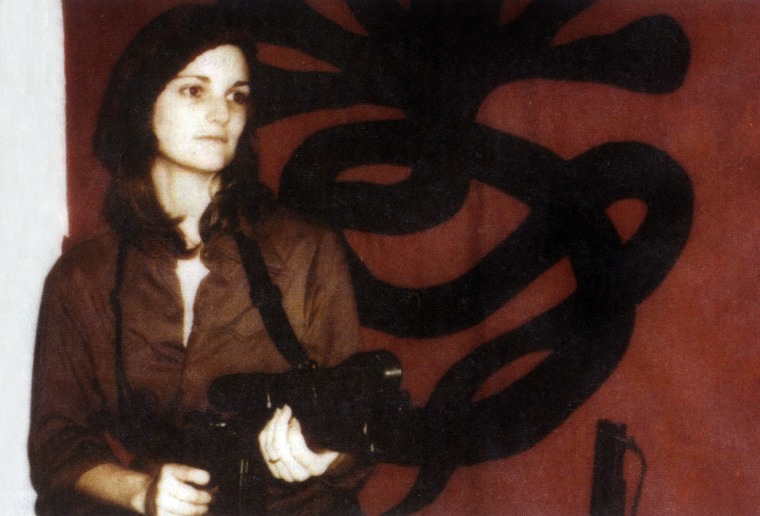 Patricia Hearst brandishing a weapon in front of SLA (Symbonese Liberation Army) april 15, 1974