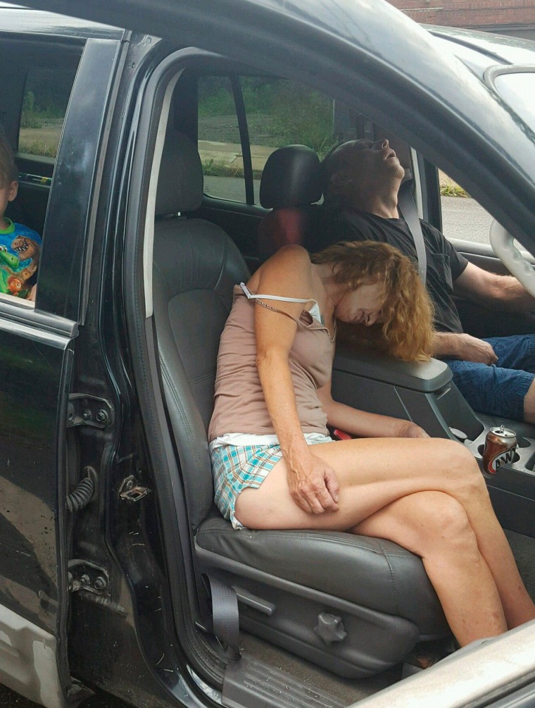 Image: East Liverpool Police Department photo showing two adults passed out in a car with a little boy in the backseat