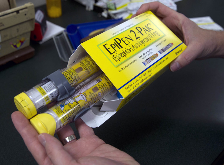 Image: A pharmacist holds a package of EpiPens epinephrine auto-injector