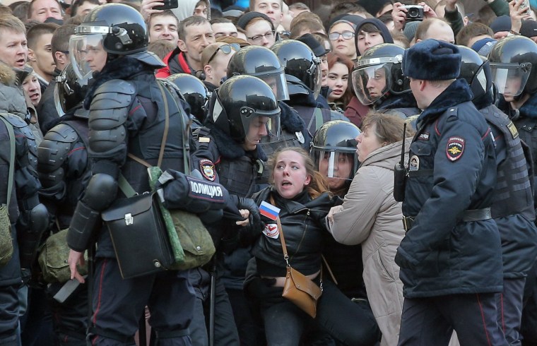 Image: Russian riot policemen detain a demonstrator.