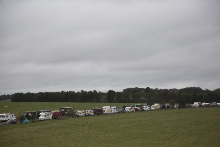 Image: A line of RVs and trailers parked outside the entrance of Stonehenge