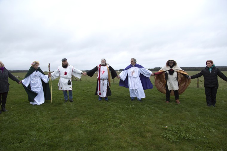 Image: Pendragon, druids and all the other visitors hold hands and form a circle around Stonehenge