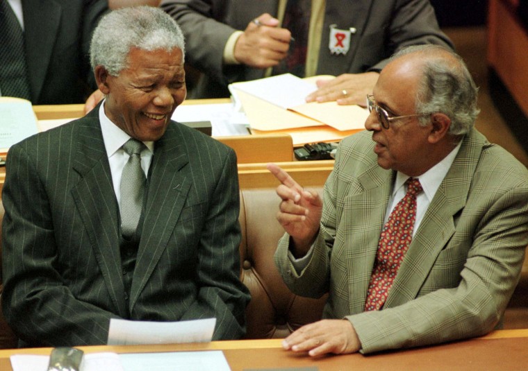 Image: President Nelson Mandela talks to fellow veteran politician Ahmed Kathrada before Mandela's address to Parliament in Cape Town March 2, 1999.