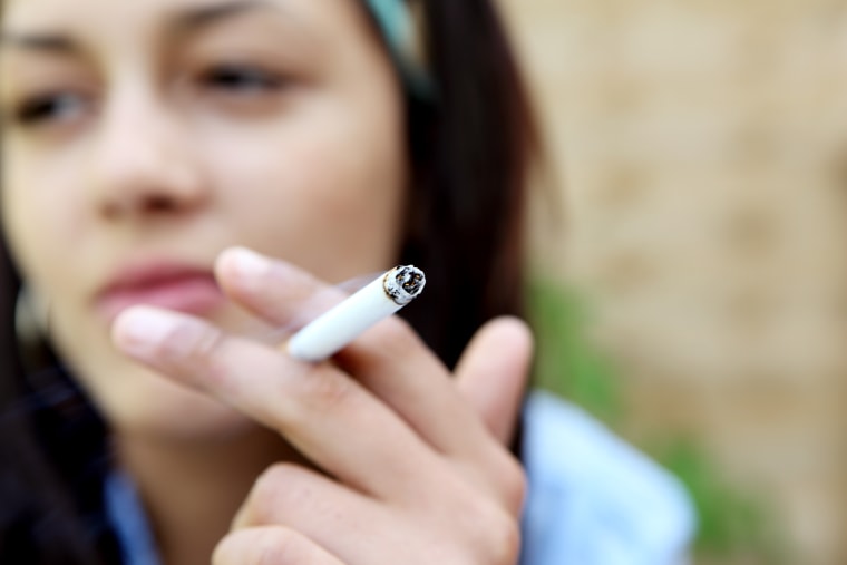 Mixed-race young woman smoking a cigarette