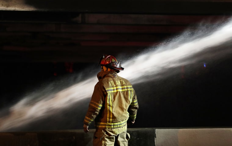 Image: A firefighter surveys the section of an overpass that collapsed from a large fire on Interstate 85 in Atlanta on March 30, 2017