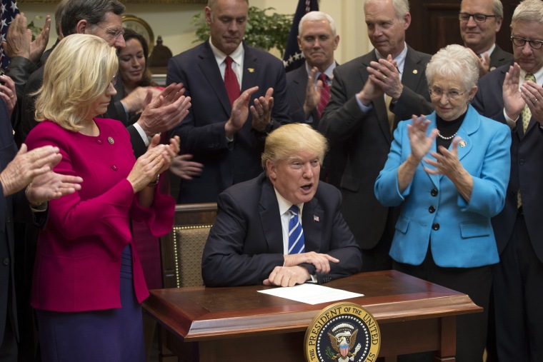 Image: President Donald Trump, flanked by Reps. Liz Cheney (R-Wyo.) and Virginia Foxx (R-N.C.), signs a series of bills during a ceremony in the Roosevelt Room of the White House in Washington.