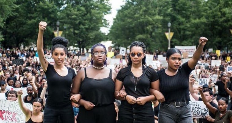 Eva Lewis (2nd from the left) led a peaceful protest of 2,000 people, in one of Chicago’s busiest intersections. 