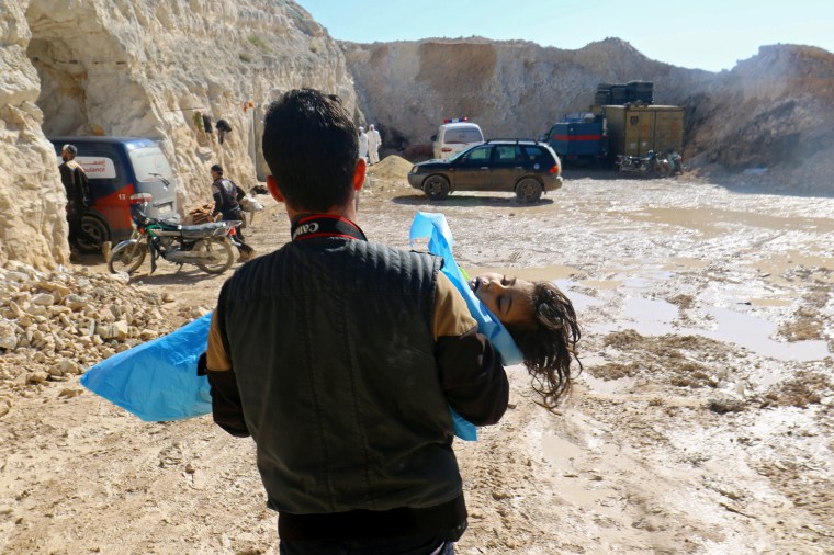 Image: A man carries the body of a dead child, after what rescue workers described as a suspected gas attack in the town of Khan Sheikhoun in rebel-held Idlib