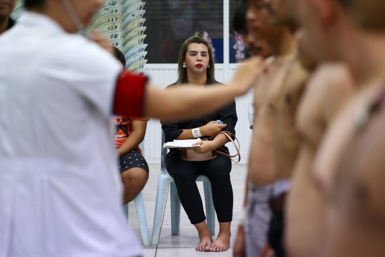 Image: A transgender waits for a health examination during an army draft held at a school in Klong Toey, the dockside slum area in Bangkok