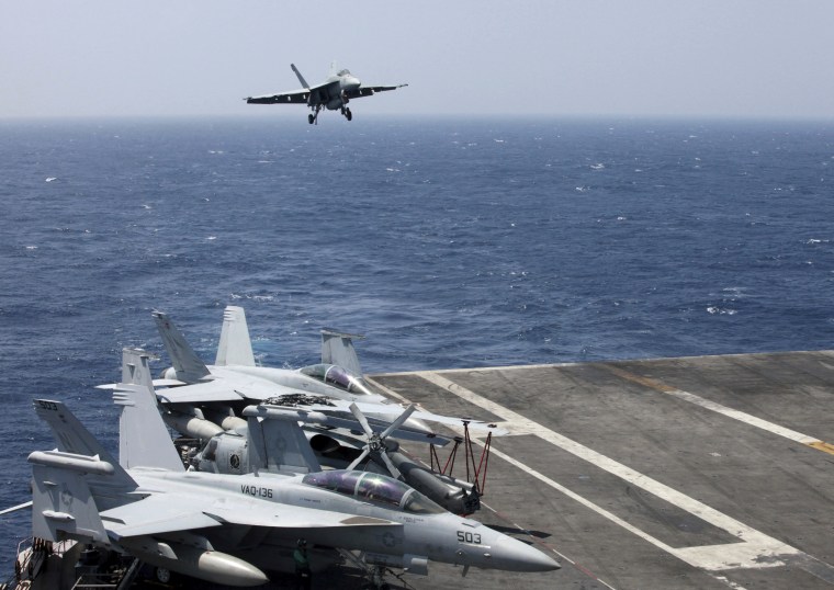 Image: A U.S. Navy F18 fighter jet lands on the U.S. Navy aircraft carrier USS Carl Vinson