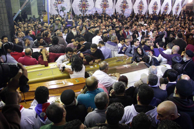 Image: Egyptian Christians mourn by caskets during the funeral of some of the victims.