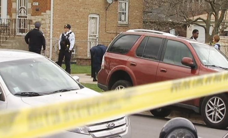 Police stand near the scene where Raymond Myles was shot dead in Chicago early morning Monday.