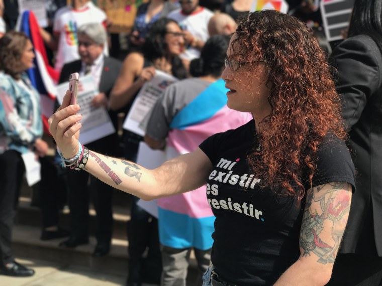 Elizabeth Marie Rivera from Latino Commission on Aids streams a video of today’s rally at the steps of the NYC City Hall to raise awareness about transgender rights in Puerto Rico and nationwide.