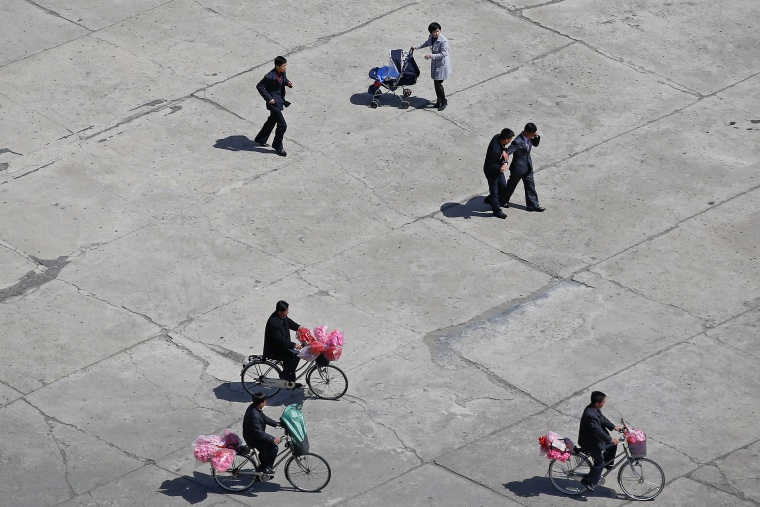 Image: People carry accessories as North Korea prepares to mark Saturday's 105th anniversary of the birth of Kim Il-sung, North Korea's founding father and grandfather of the current ruler, in central Pyongyang
