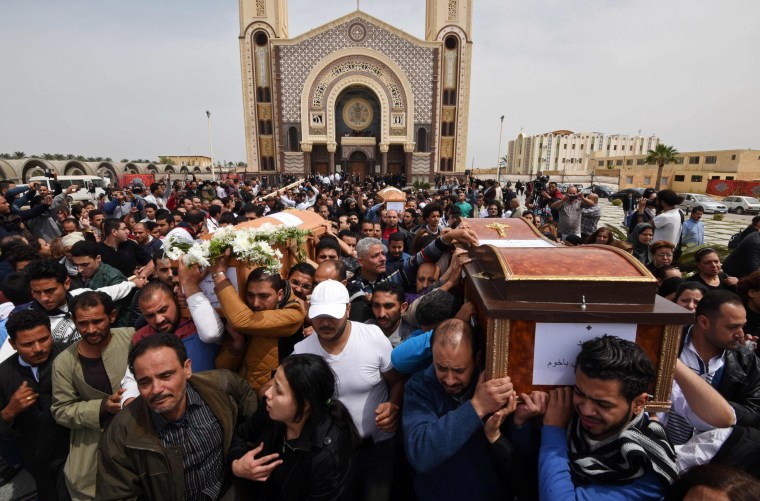 Image: Mourners carry the coffins of victims of a bomb at a Coptic church in Alexandria