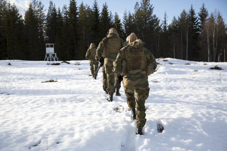 Image: Female soldiers march on the snow-covered hillside after a military training exercise at the Terningmoen Camp in Elverum, Norway