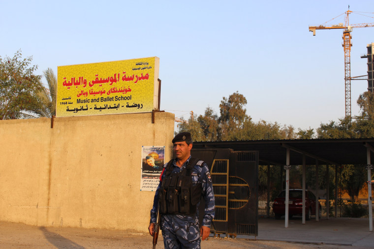 Image: Armed policemen guard the Baghdad Music and Ballet School's gates