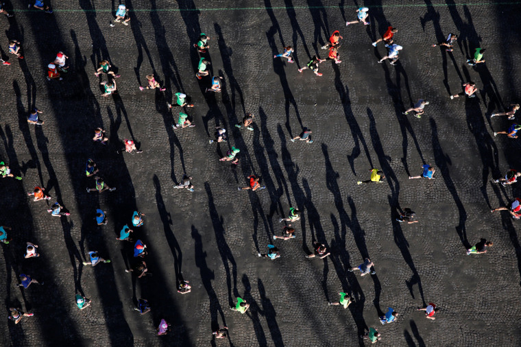 Image: Competitors run down the Champs Elysees below the Arc de Triomphe at the start of the 41st Paris Marathon in Paris