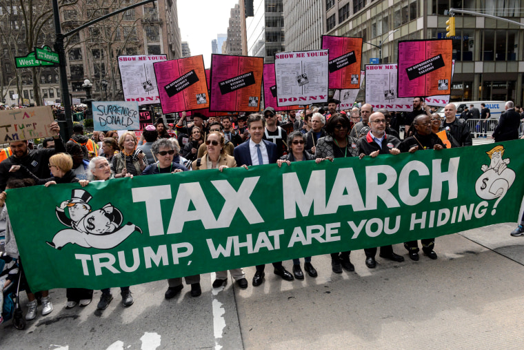 Image: People participate in a Tax Day protest on April 15, 2017 in New York City. Activists in cities across the nation are marching today to call on President Donald Trump to release his tax returns.