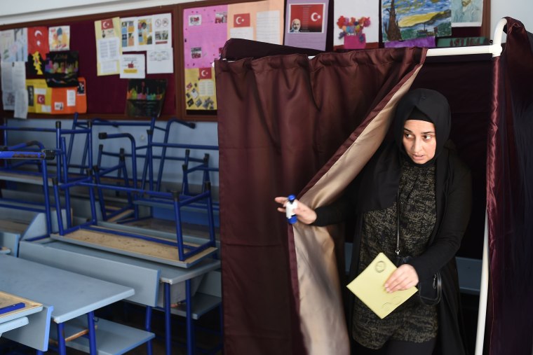 Image: A woman holds her ballot in the referendum on expanding the powers of Turkey's president.