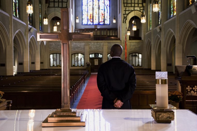 Mixed race pastor standing in front of church altar