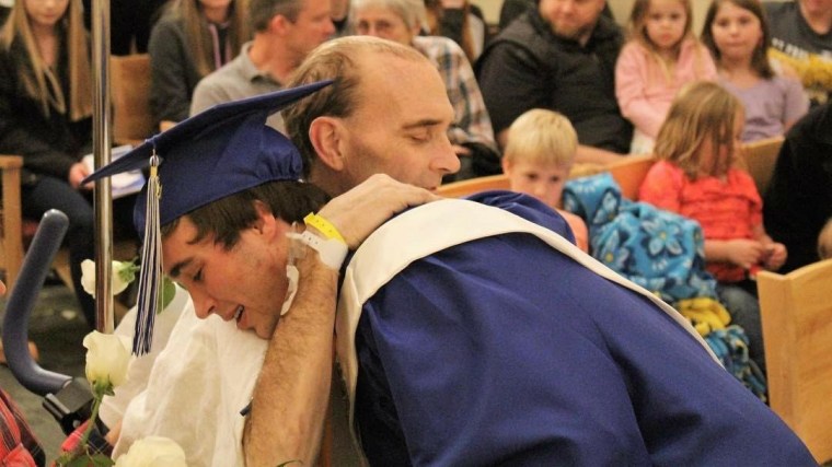 Noah Harrahill, 18, hugs his father, Dan Harrahill at his graduation ceremony on March 24.