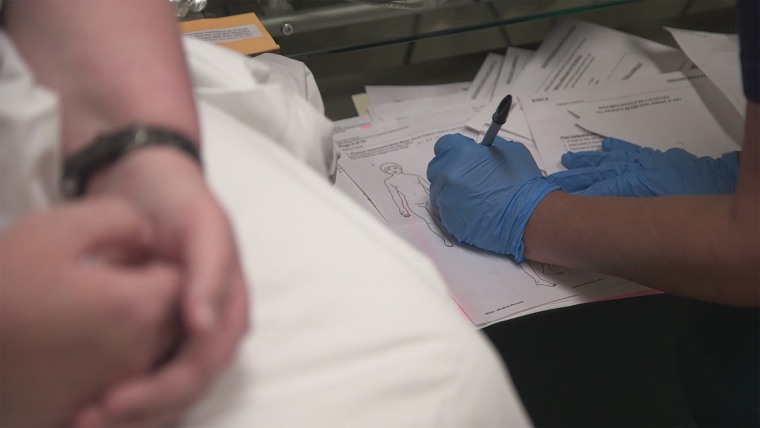 Nurse writing on a rape kit diagram in "I Am Evidence."