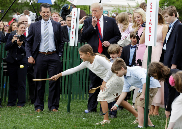 Image: U.S. President Donald Trump and his son Donald Trump, Jr., watch children roll Easter Eggs at 139th annual White House Easter Egg Roll