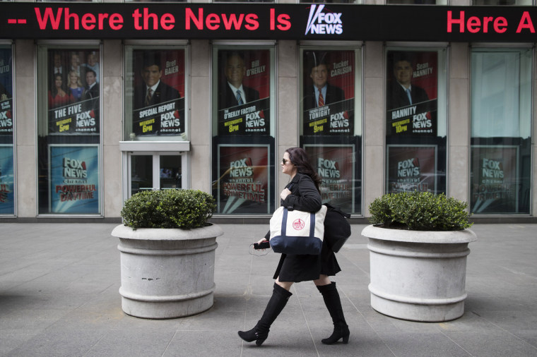 Image: A woman walks past the News Corp. headquarters