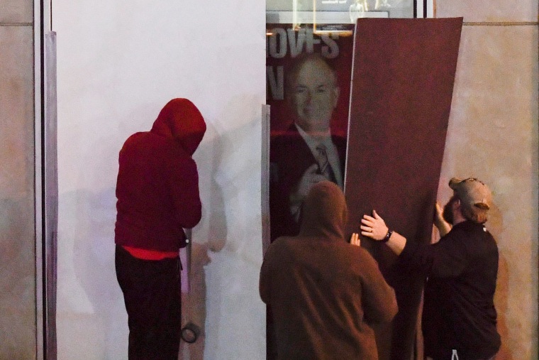 Image: Men place boards over Bill O'Reilly poster outside of the Fox News offices in Manhattan, New York