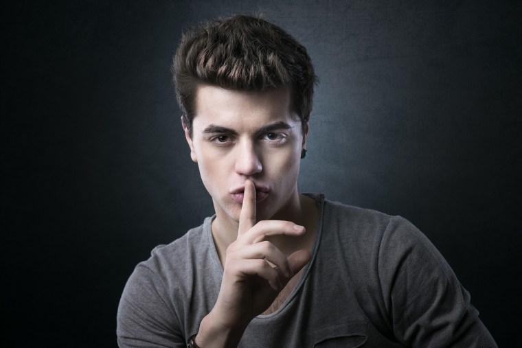 Young man making silence gesture