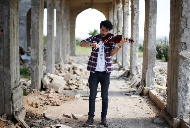 Image: Ameen Mukdad, a violinist from Mosul who lived under ISIS's rule for two and a half years where they destroyed his musical instruments, performs in eastern Mosul