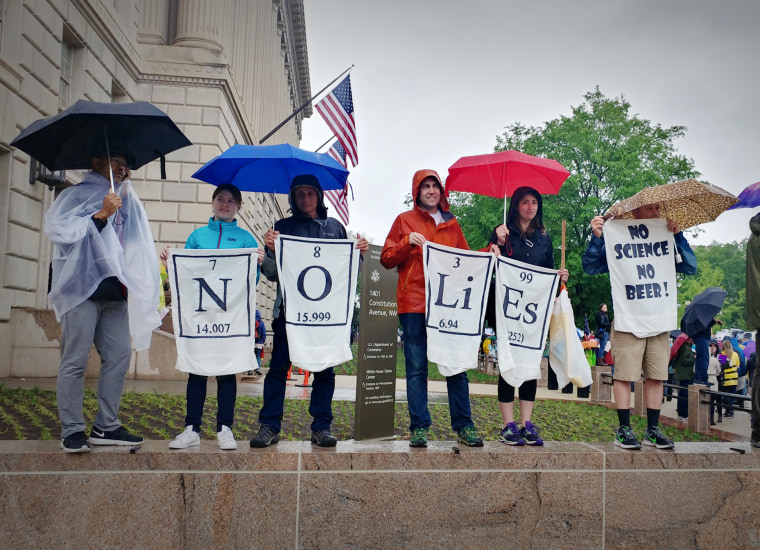 Image: Protesters entertained one another as they made their points with home-made signs along Constitution Avenue in Washington.