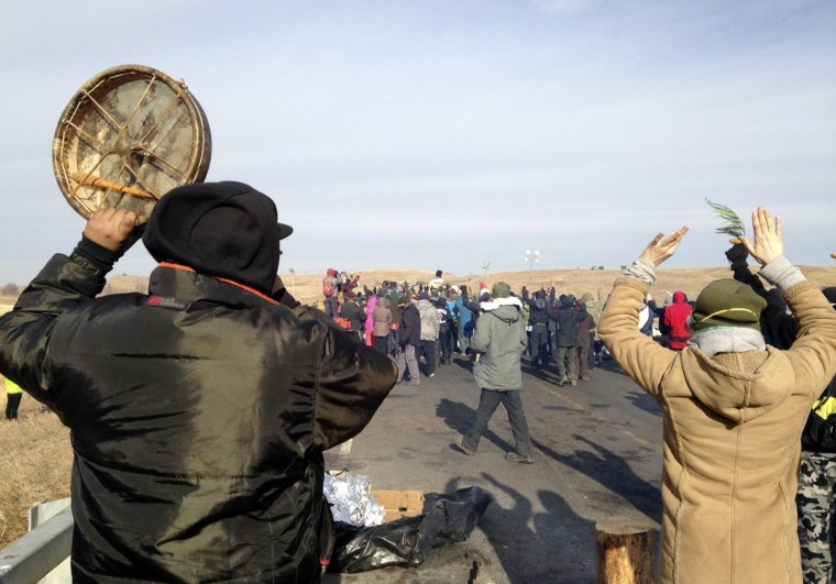 Protesters against the Dakota Access oil pipeline congregate Monday, Nov. 21, 2016, near Cannon Ball, N.D., on a long-closed bridge on a state highway near their camp in southern North Dakota.