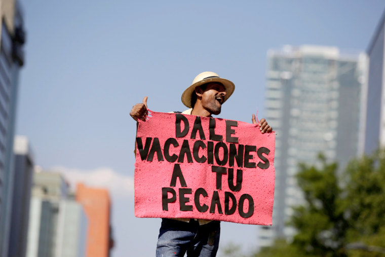 Image: A demonstrator holds a placard as he participates in the March for Science rally in Mexico City, Mexico. The placard reads \"Give holiday to your sin.\"